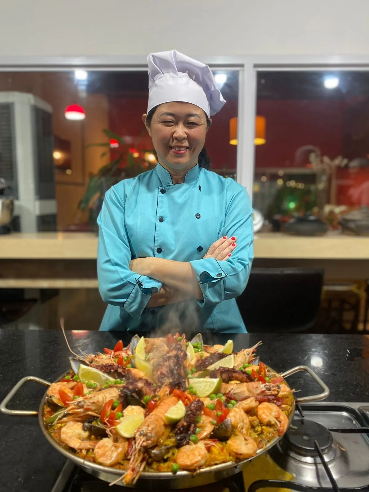 Chef Thaís Okamoto ensinando em aula de culinária